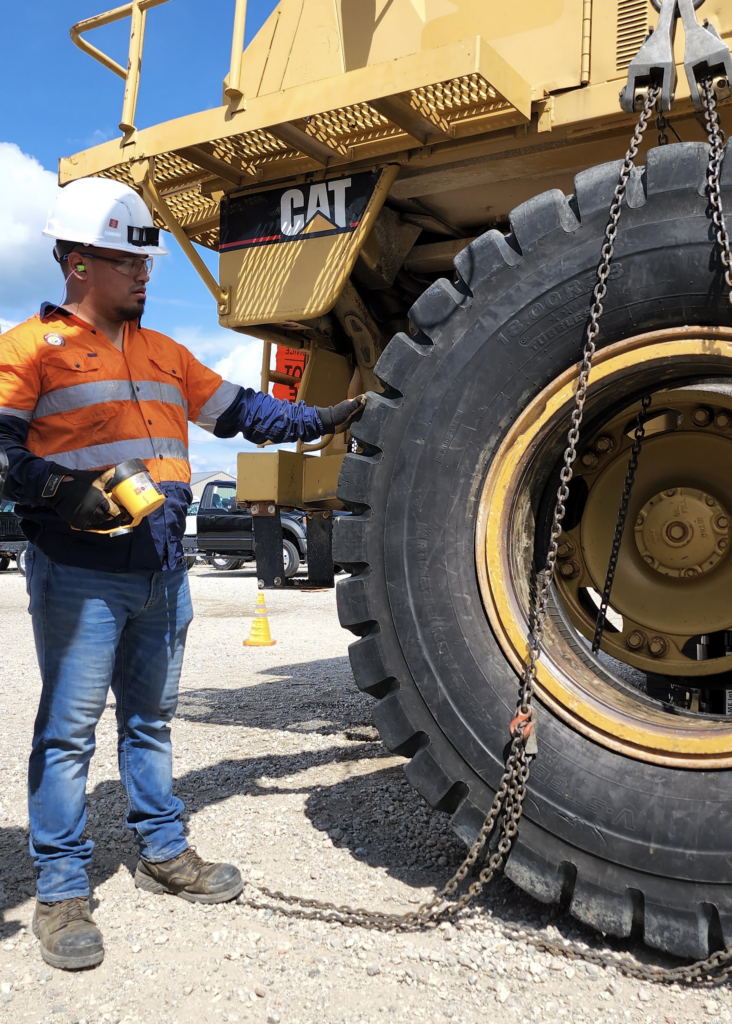 A man standing next to a large truck equipped with Klinge tyre management systems for off the road applications.