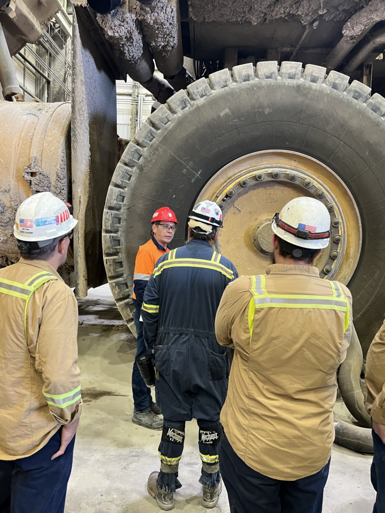 Rio Tinto Men Standing Around A Tyre