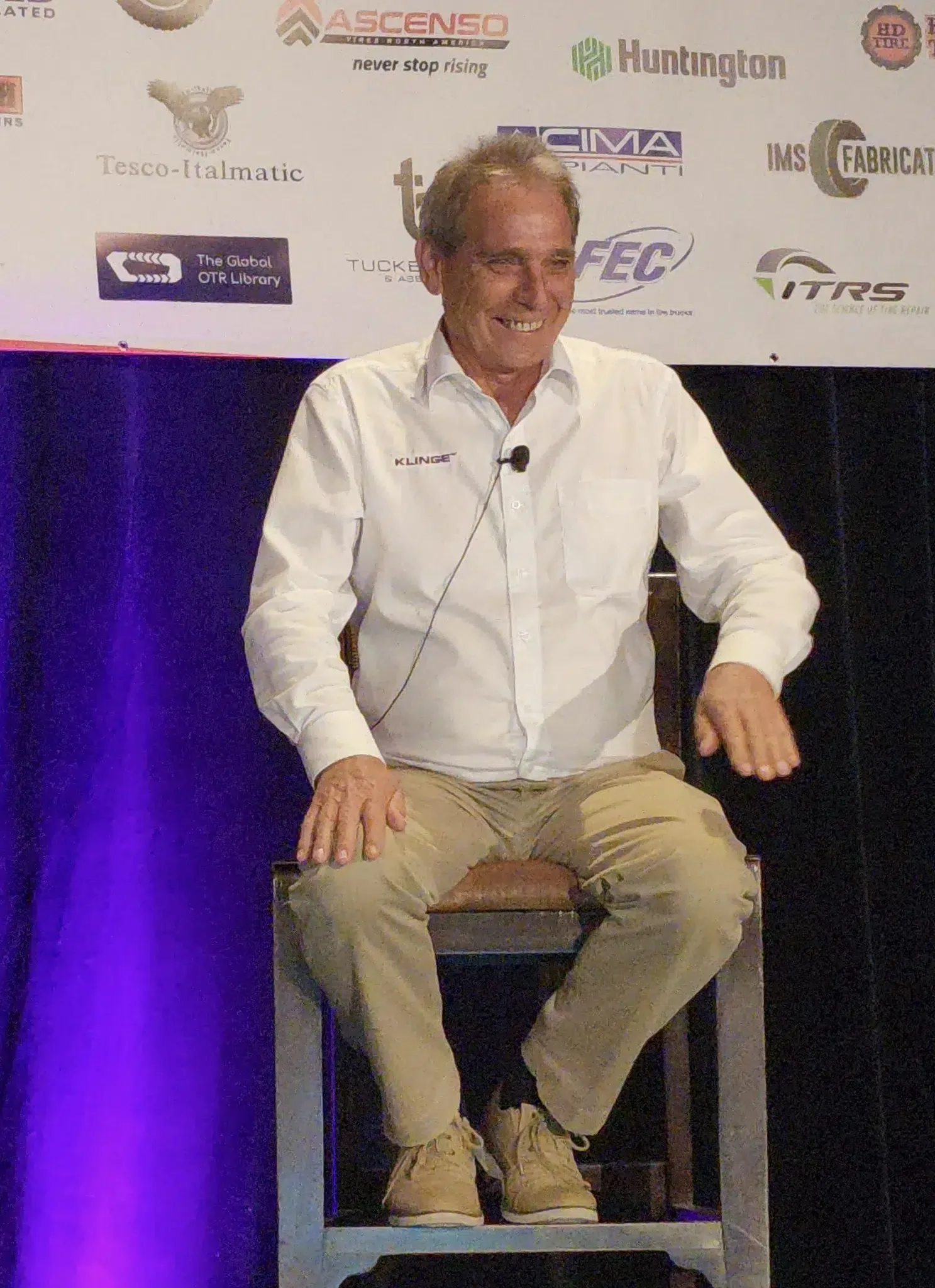 A man sitting on a chair at an event focused on tyre management systems.