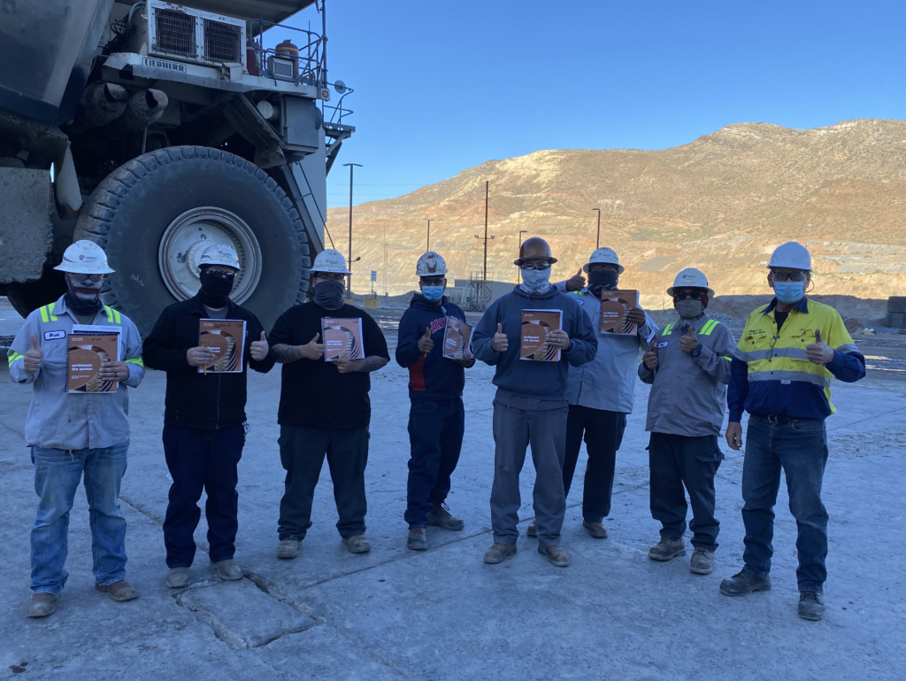 A group of people wearing face masks and holding signs advocating for tyre management systems.
