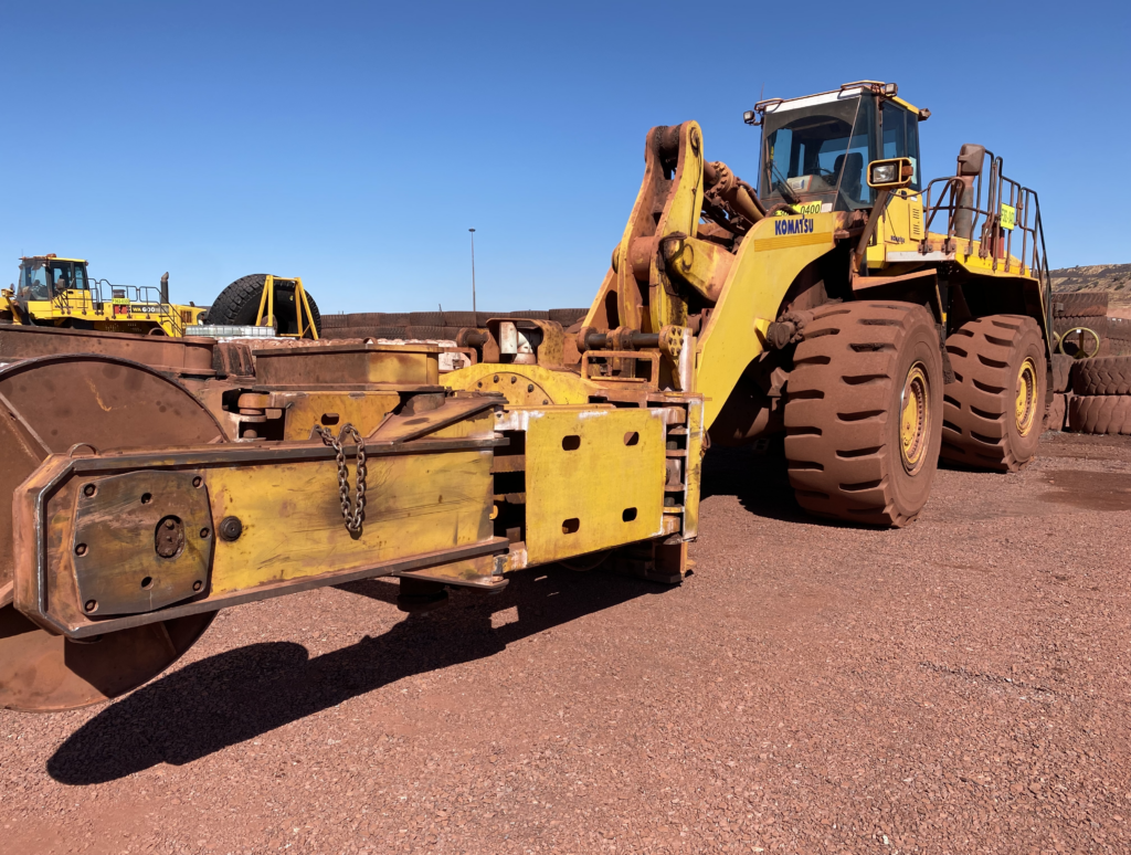 An otr bulldozer is parked on a dirt road.
