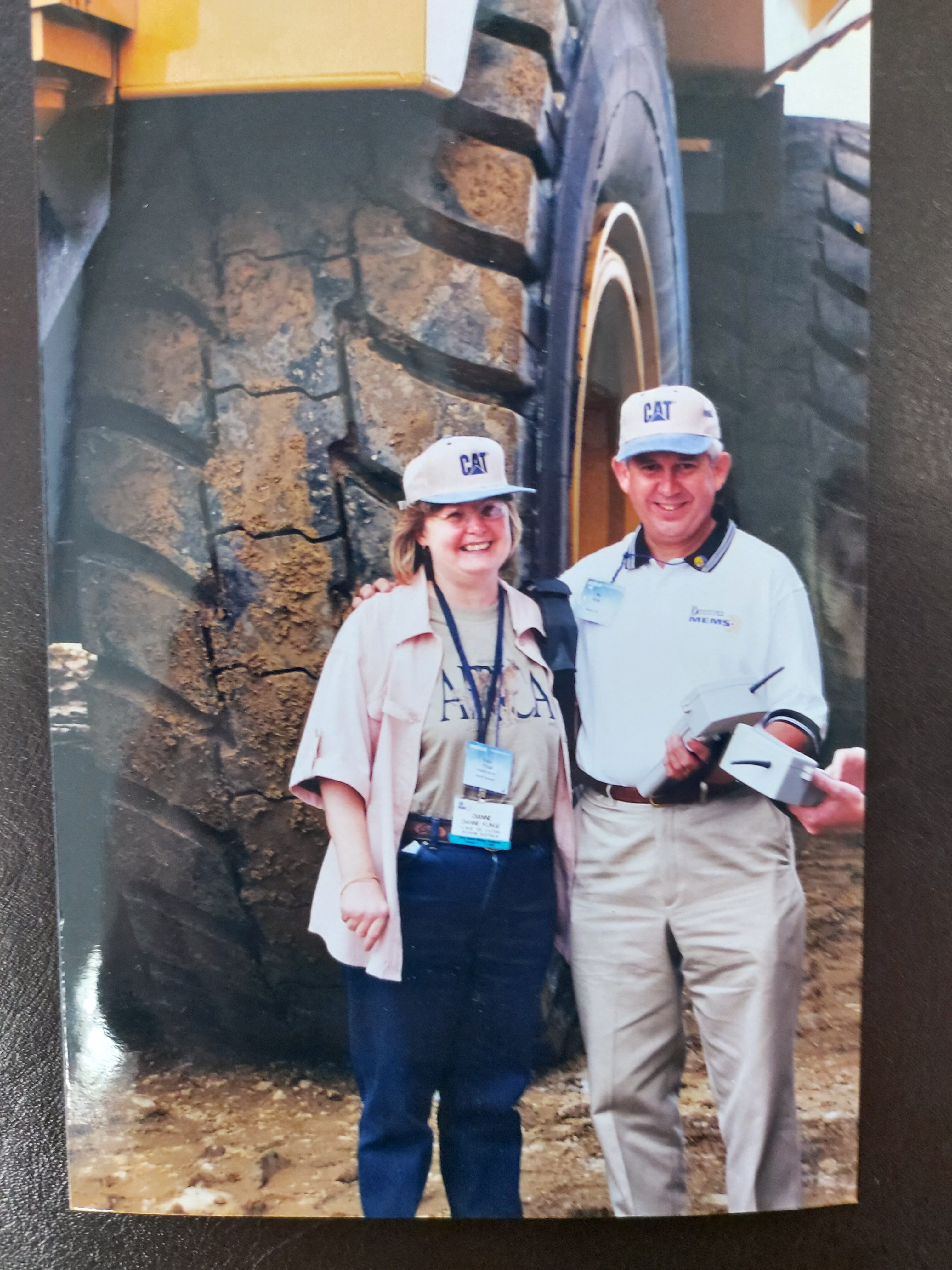 Our Man And Woman Standing In Front Of A Large Truck